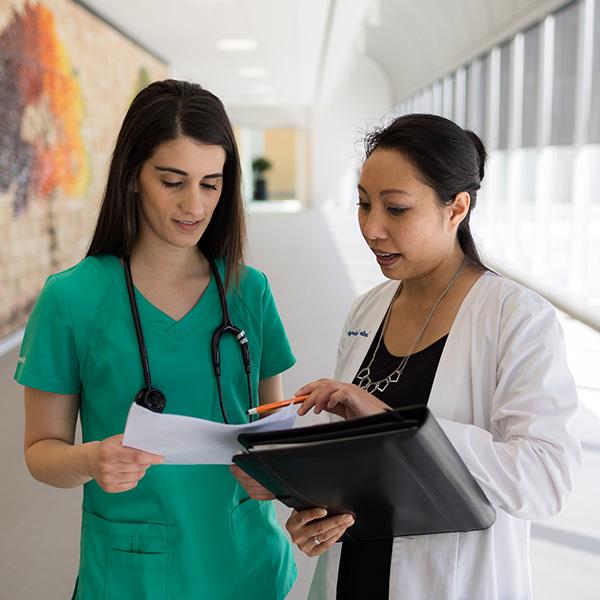 Two females having a conversation in a hospital